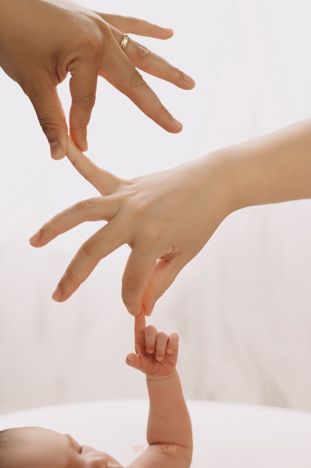 Ảnh cận bàn tay mẹ và tay bé sơ sinh chạm nhau