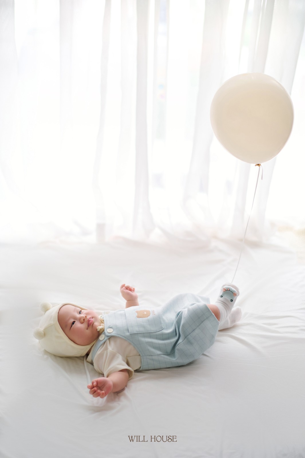Bé nằm cạnh bóng bay trắng, khung cảnh nhẹ nhàng tại studio Cần Thơ