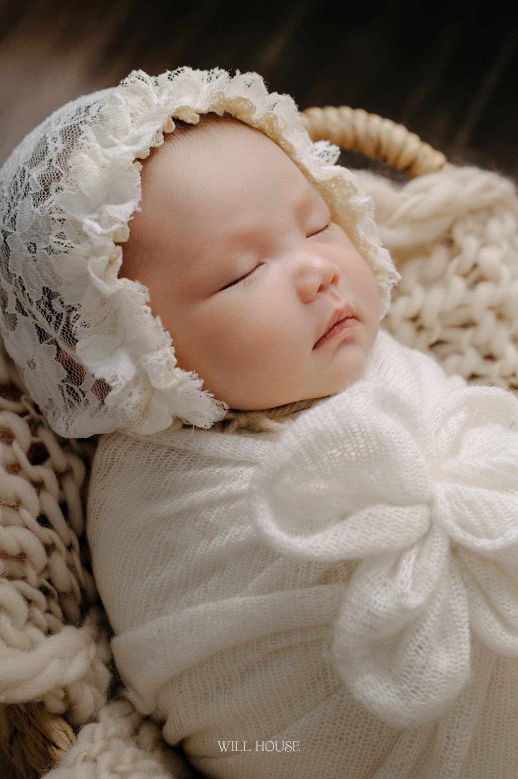 Bé sơ sinh đội mũ ren ngủ trong giỏ mây, phong cách newborn cổ điển tại Cần Thơ